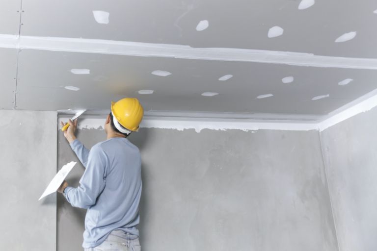 Plasterer finishing a ceiling on site